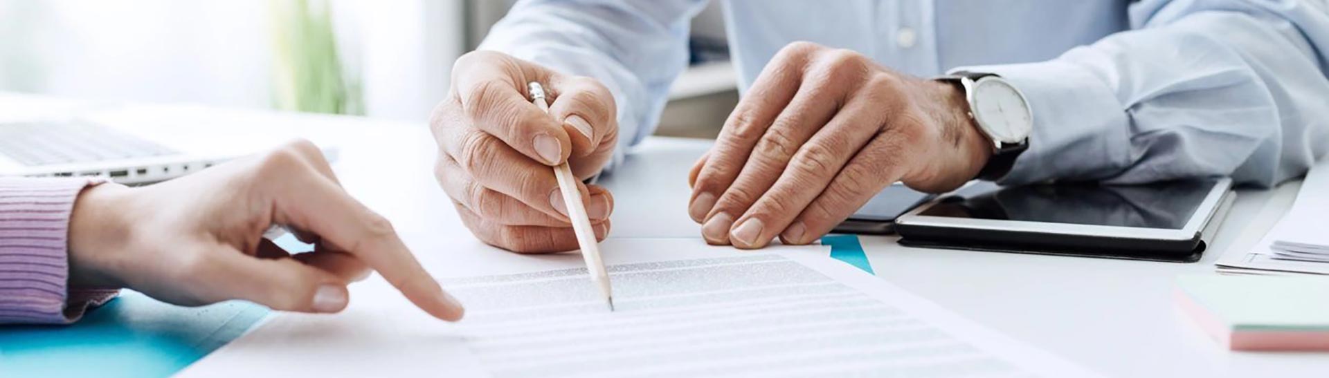 A person writing on paper with a pencil.